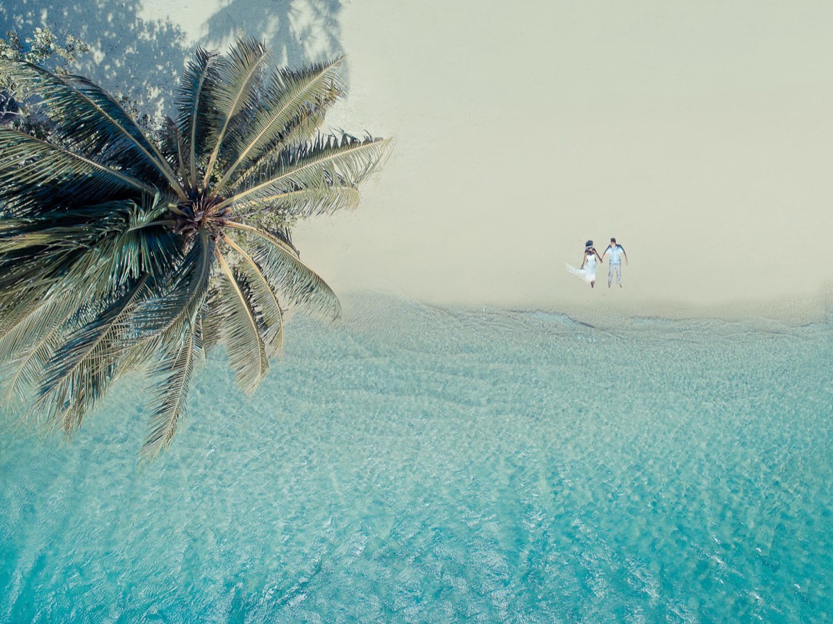 Couple de mariés sur une plage vue du ciel